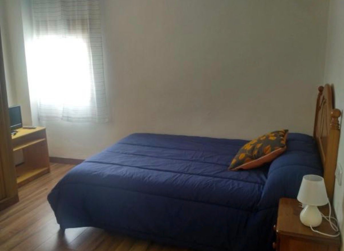 Dormitorio con cama de matrimonio y ventana